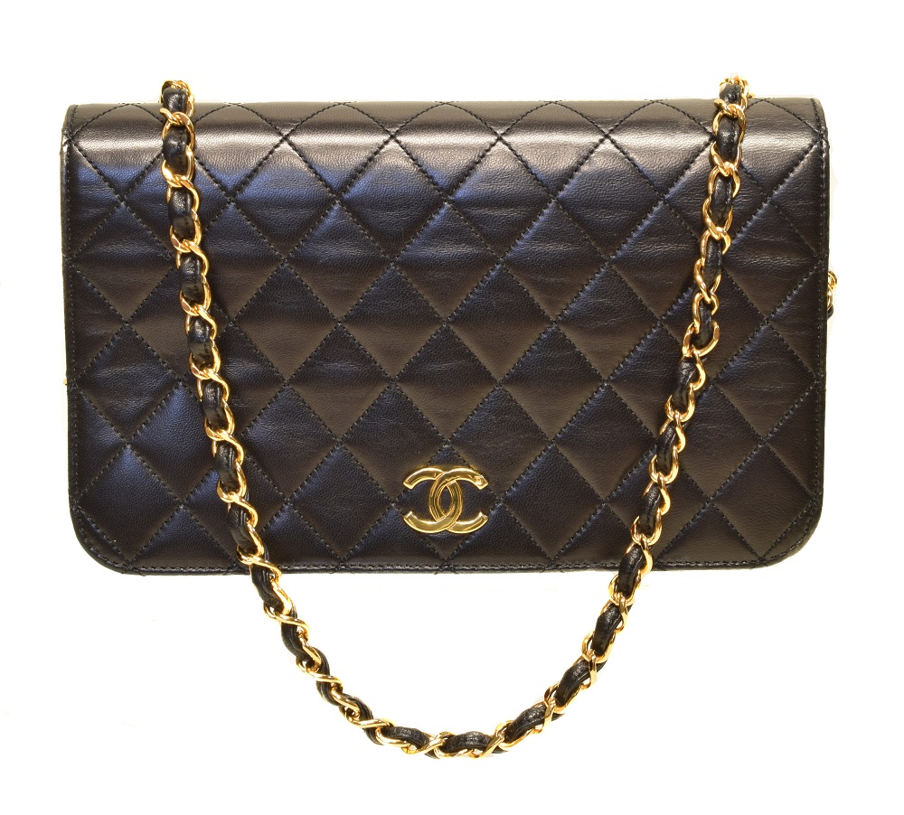 A Chanel Mademoiselle Timeless Full Flap Shoulder Bag, circa 1997-9, the black quilted calf leather exterior with interlaced chain straps and gold tone hardware, serial no. 5145297. With maker's dustbag, card, and box. (Qty: 1) 23x15x5cm Sold for £1,952
