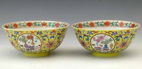 A pair of Chinese porcelain bowls adorned with detailed floral patterns, showcasing traditional craftsmanship.