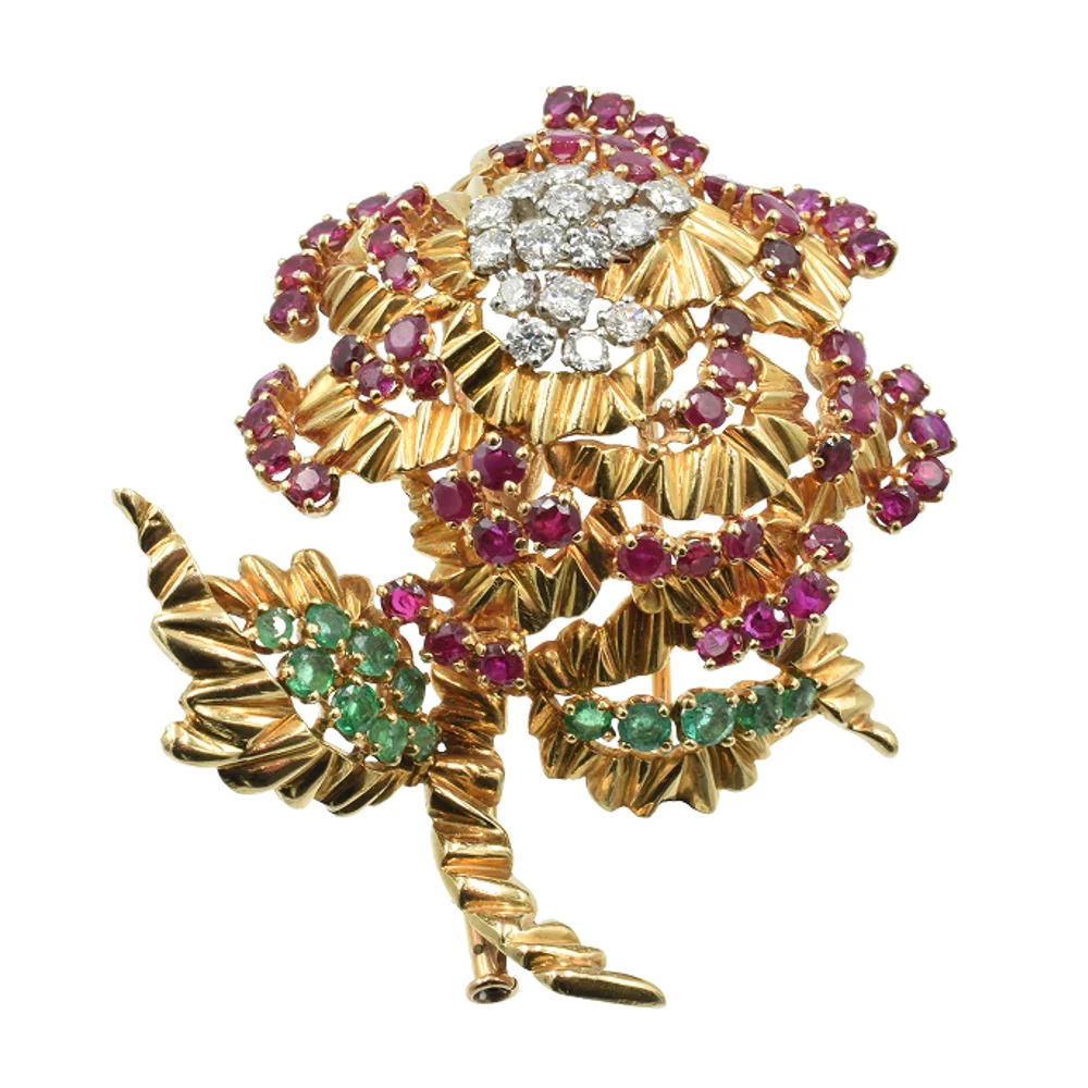 A gold and diamond flower brooch adorned with pink and green gemstones, showcasing intricate floral design details.