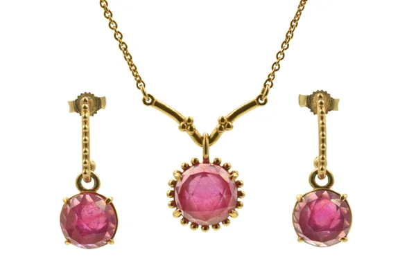 Gold necklace and matching drop earrings with faceted pink gemstones in ornate settings, displayed on a white background. The coordinated jewellery feels elegant and vintage-inspired.