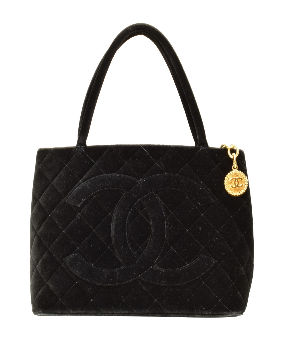 A Chanel Medallion Shoulder Bag, circa 1997-9, the black velvet quilted canvas exterior with black canvas strap and gold tone hardware, serial no. 5411744. (Qty: 1) 29.5x25x14cm Sold for £1,159