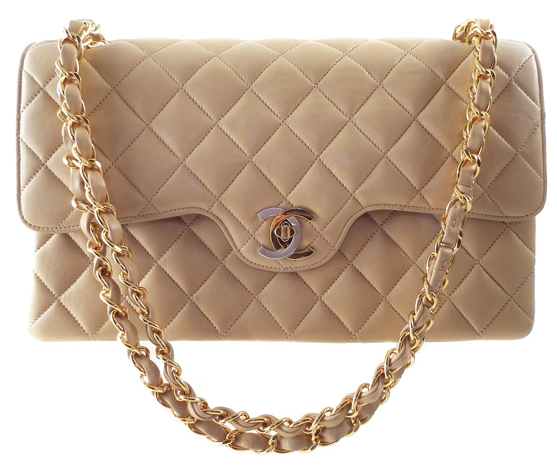 A rare Chanel medium double flap handbag, circa 1991-4, the beige quilted lambskin leather exterior with gold and silver-tone locking clasp, gold-tone double chain shoulder strap, serial number 2827451. Dimensions 26 x 16 x 7cm. With maker's authenticity card. 26 x 16 x 7cm Sold for £2,196